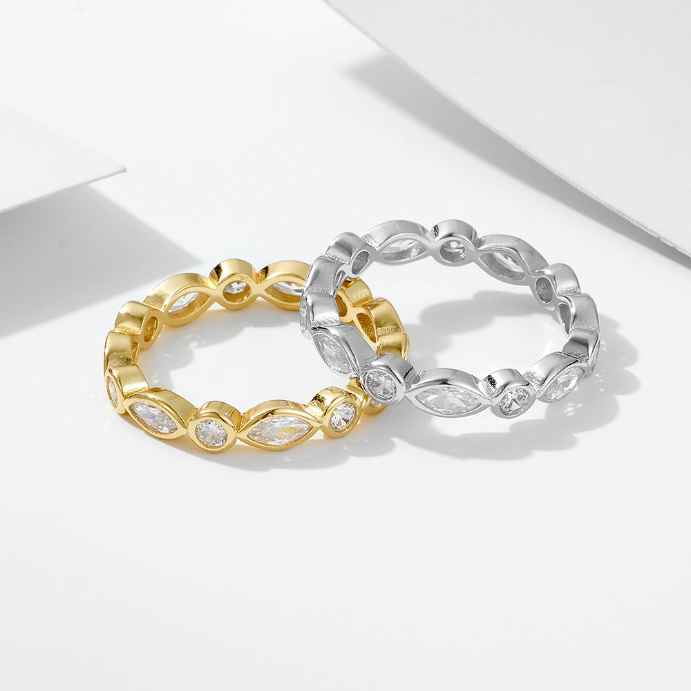 Two eternity rings, one in gold and one in silver, both featuring alternating marquise and round-cut crystals in a bezel setting.