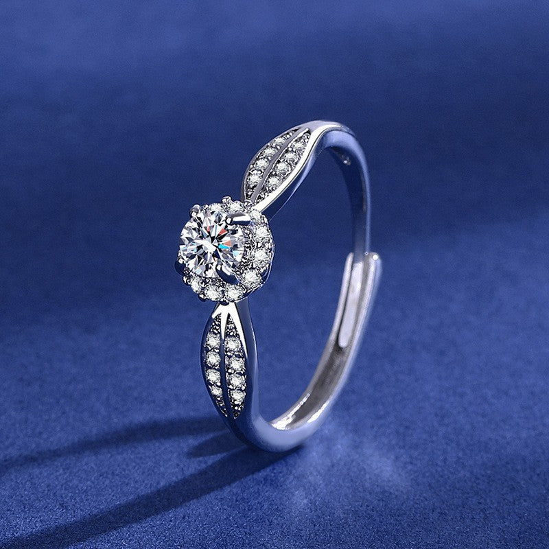 Silver marquise-shaped halo ring featuring a large center crystal surrounded by a double border of smaller stones on a shimmering teal background.