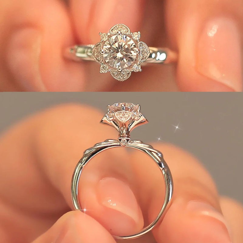 Top and side views of a vintage-style silver ring featuring a floral-shaped halo with a brilliant-cut center stone.